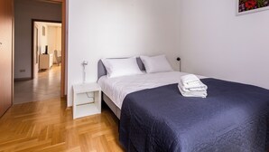 Ein Schlafzimmer mit Bett, Nachttisch und einem Bild an der Wand.