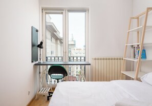 Relax in this cozy retreat with a single bed, desk, and chair, plus a balcony with city views.
