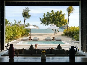 A poolside view with lounge chairs, umbrellas, and a view of the beach and ocean. - Kuara Lombok - Adults Only Boutique Resort (Mertak)