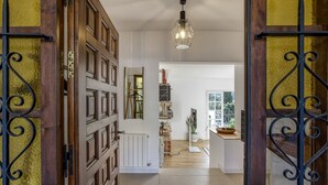 A hallway leading to a kitchen with a white radiator, wooden cabinets, and a hanging light fixture. - Villa 'Les Aulines' with Mountain View, Wi-Fi and Air Conditioning (Calonge)