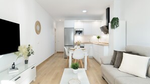 A modern living room with a flat-screen TV, a glass coffee table, and a sofa. - Apartment 'Calderon' with Air Conditioning (Barbate)