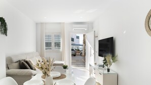 A modern living room with a sofa, dining table, and TV. - Apartment 'Calderon' with Air Conditioning (Barbate)