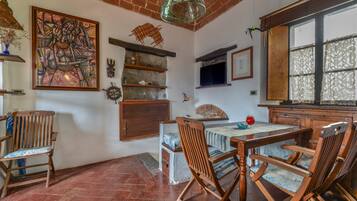 Un comedor con techo de ladrillo, mobiliario de madera y un cuadro grande en la pared.
