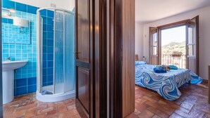 Ein Badezimmer mit Dusche, Waschbecken und einer blauen Fliesenwand.