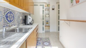 Een keuken met houten kastjes, een betegelde spatwand en een ingebouwde radio.