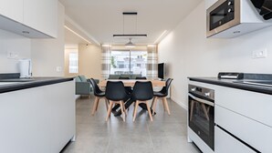 Una cocina moderna con comedor, electrodomésticos integrados y vistas al exterior.