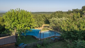 Una piscina rodeada de árboles y una valla de madera.
