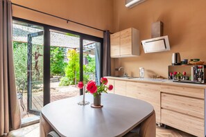 Une cuisine moderne dotée d’une grande fenêtre, d’un évier et d’un coin repas avec une table et des chaises.