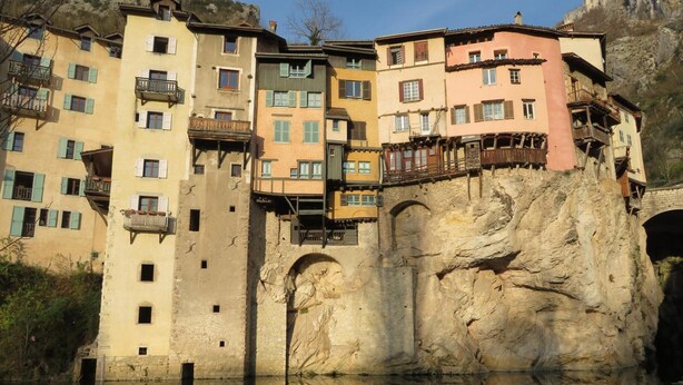 A multi-story building with balconies, a stone facade, and a reflection in the water. - Apartment 'Au Bonheur Suspendu' with Private Terrace, Wi-Fi and Air Conditioning (Pont-en-Royans)