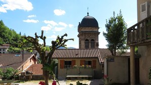 A courtyard with a building featuring a dome, a stone bench, and a sign indicating a place of worship. - Apartment 'Au Bonheur Suspendu' with Private Terrace, Wi-Fi and Air Conditioning (Pont-en-Royans)