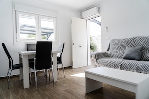 Una habitación moderna con una mesa de comedor, dos sillas, un sofá y un banco.