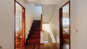 Una scala conduce a una camera da letto con un letto e una finestra.