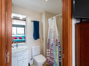 Une salle de bain avec des toilettes, un lavabo et un rideau de douche.