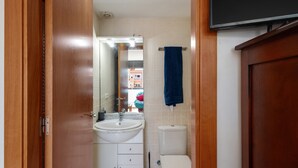 Un baño con lavamanos, inodoro y espejo.