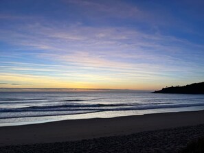 Una playa con cielo despejado y mar tranquilo.