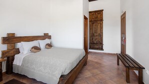 Ein Schlafzimmer mit einem hölzernen Bett, einer Bank und einem Kleiderschrank.