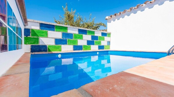 Piscina com parede revestida em azulejo com padrão geométrico.