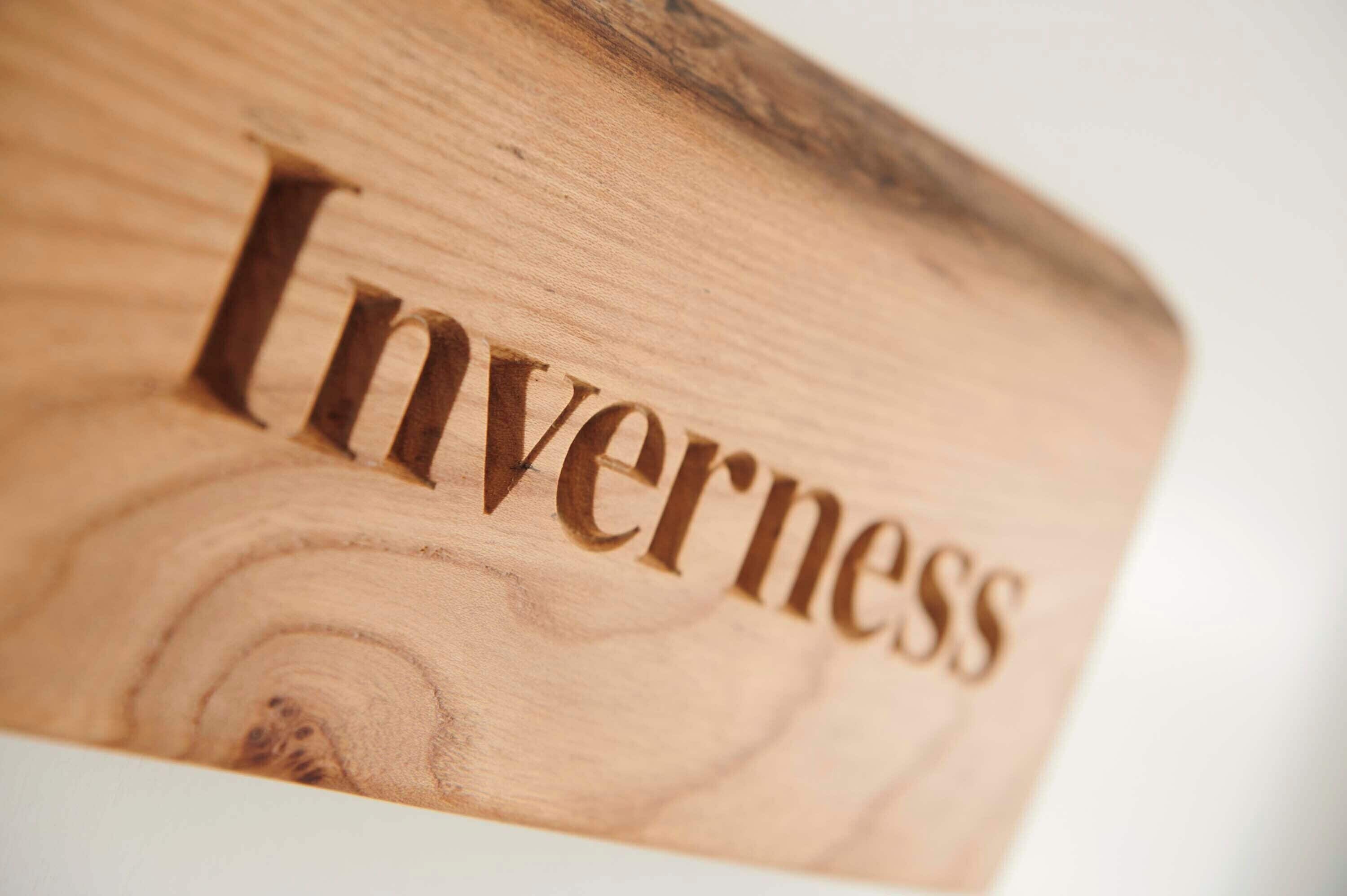 Um bloco de madeira com a palavra 'Inverness' esculpida.