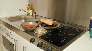 A kitchen with a stainless steel stove, a sink, and a bowl of soup. - Downright Gabbler (Beauly)