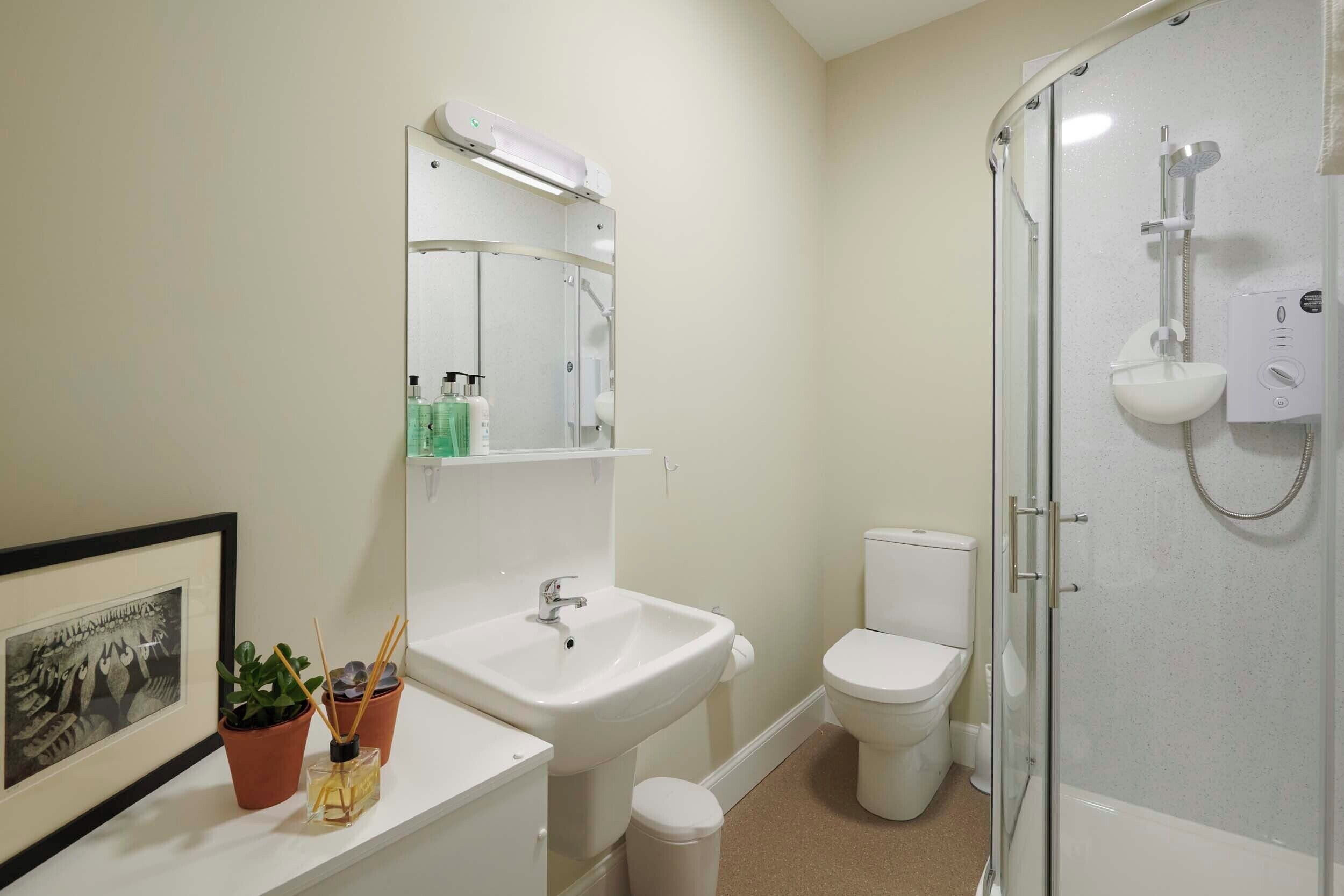A bathroom with a sink, toilet, and glass-enclosed shower.