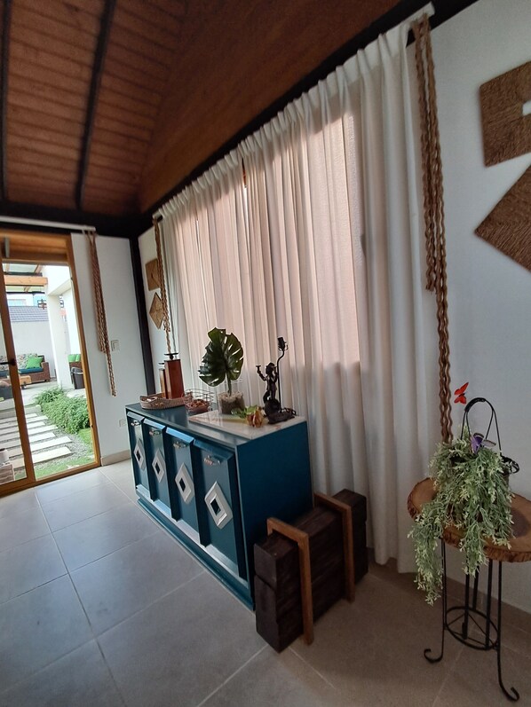 A room with a blue cabinet, a potted plant, and a statue on a small table.