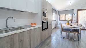 Una cocina moderna con horno empotrado, microondas y doble pileta.