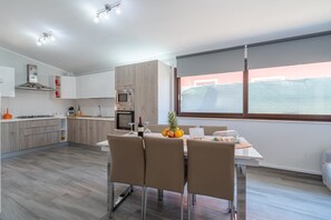 A modern kitchen with a dining area, a large window, and a view of the outside. - Villa 'Casa Helios Con Idromassaggio' with Private Terrace, Wi-Fi and Air Conditioning (Siracusa)