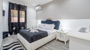 Un dormitorio moderno con cama, mesitas de noche, cómoda y ventana con cortinas.