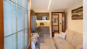 A compact living space with a kitchenette, a sofa, and a dining area. - Apartment 'Sotto' with Private Terrace and Wi-Fi (Morgex)