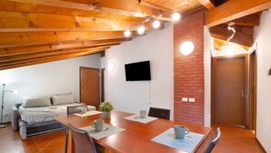 Une pièce de taille modeste comprenant un lit, une table à manger et un téléviseur fixé au mur.