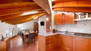 Une cuisine avec des meubles en bois, un plan de travail en granit et une cuisinière à gaz.