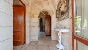 A stone corridor with wooden doors and a white pedestal table. - Room 'Masseria Copertini - Gattini' with Wi-Fi and Air Conditioning (Vernole)
