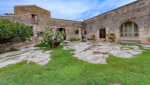 A courtyard with stone walls, a small building, and potted plants. - Room 'Masseria Copertini - Gattini' with Wi-Fi and Air Conditioning (Vernole)