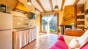 A kitchen with a TV, a sink, and a dining area with a table and chairs.