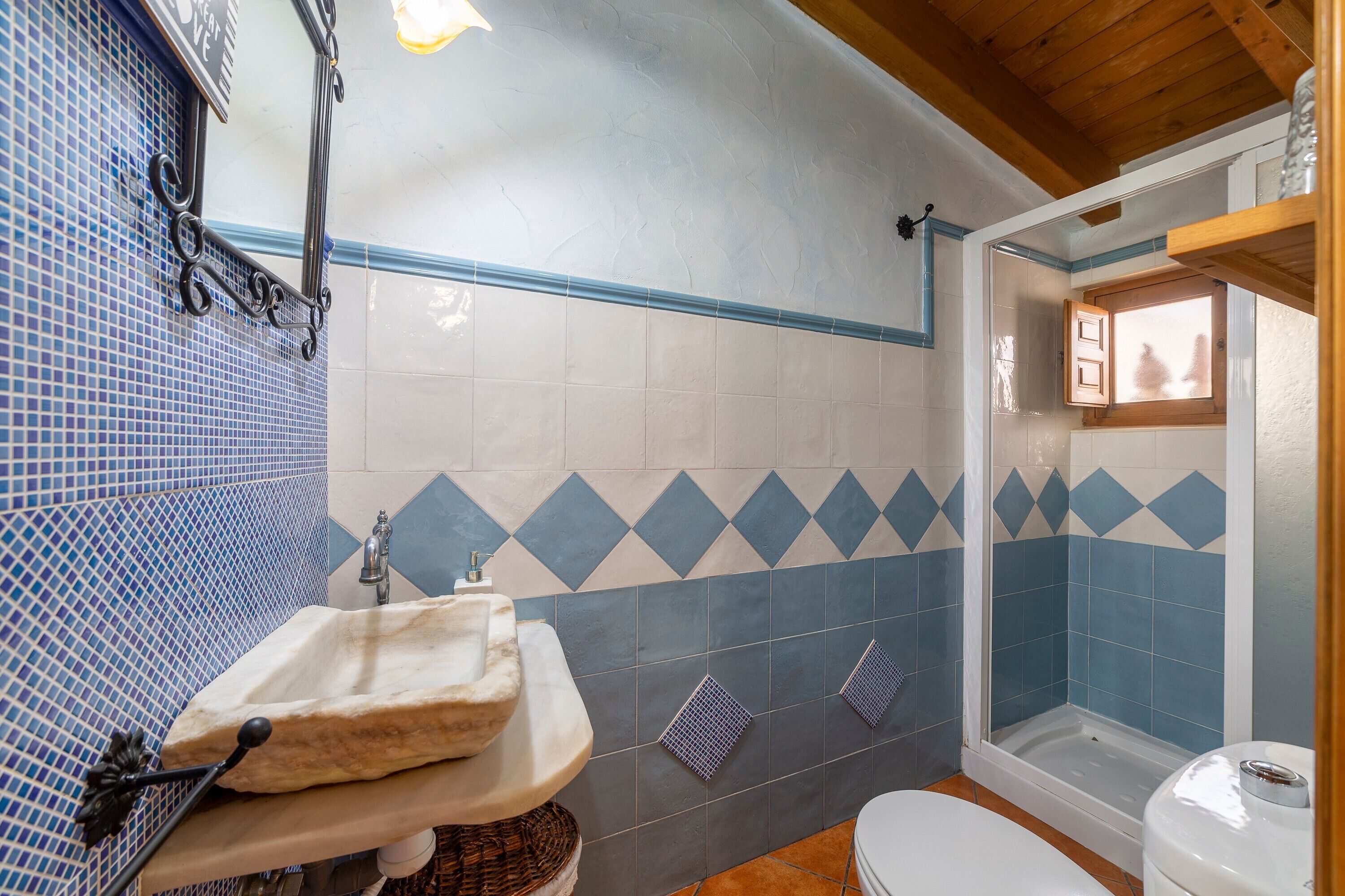 A bathroom with a sink, toilet, and shower area.