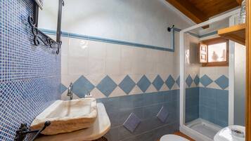A bathroom with a sink, toilet, and shower area.