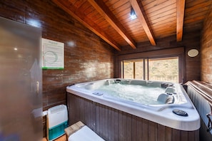 A wooden cabin interior with a hot tub, a window, and a sign on the wall. - Country House 'Tenguerengue' with Mountain View, Wi-Fi and Air Conditioning (Laroya)