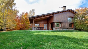Une maison moderne avec des fondations en pierre, de grandes fenêtres et un patio couvert.