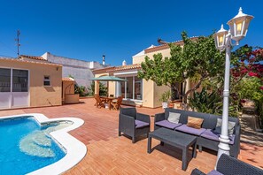 Une piscine, du mobilier d’extérieur et un patio offrant une vue sur un bâtiment.