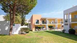 A residential building with a courtyard, balconies, and a well-maintained lawn.