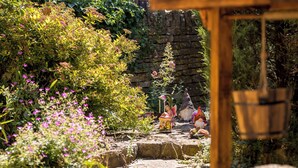 A garden pathway with statues and a stone wall. - Broadway Scandi Chic Cottage (Broadway)