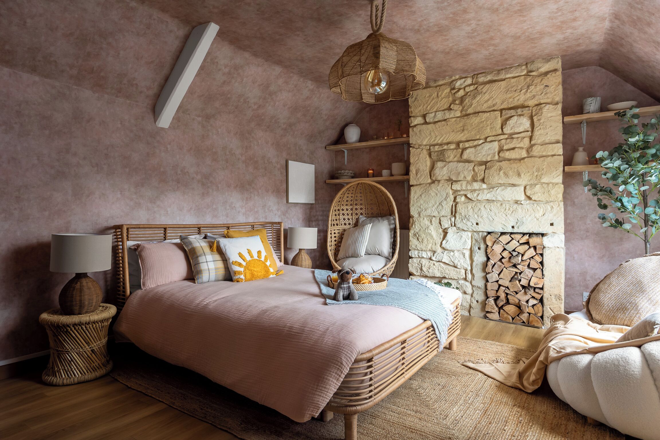 Een slaapkamer met een bed, nachtkastjes, een hanglamp, een stenen muur en een plank met decoratieve objecten.