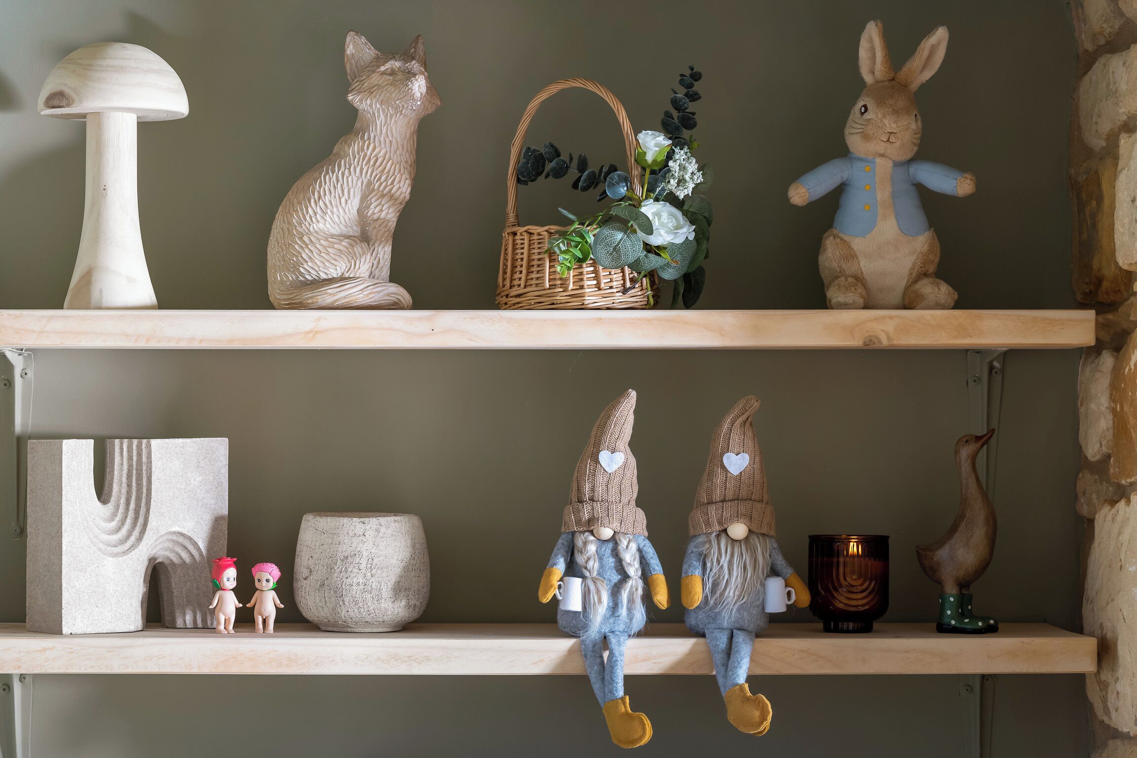 Two shelves with various decorative items including a cat, a rabbit, a basket with flowers, and two gnome figures.
