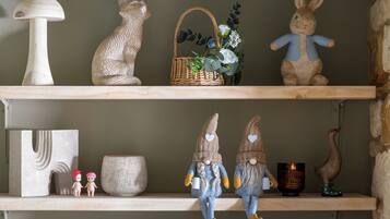 Two shelves with various decorative items including a cat, a rabbit, a basket with flowers, and two gnome figures.