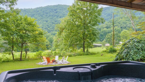 A hot tub with a view of a grassy area and trees.