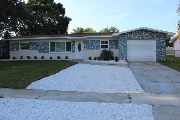 A single-story house with a stone facade, a front garage, and a well-maintained lawn. - Spacious 4-bedroom house in fantastic Tampa with AC, WiFi (Tampa)