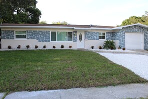 A two-story house with a stone facade, a front garage, and a well-maintained lawn. - Spacious 4-bedroom house in fantastic Tampa with AC, WiFi (Tampa)