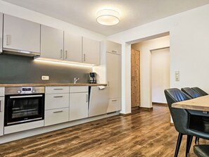 Een koelkast, een magnetron, kookgerei, borden en bestek