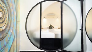 A room with a bed, a heart-shaped decoration, and a circular mirror. - Tunnel Urban Retreat (Siem Reap)