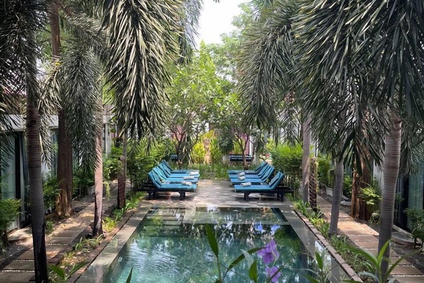 Una piscina al aire libre, sillones reclinables de piscina